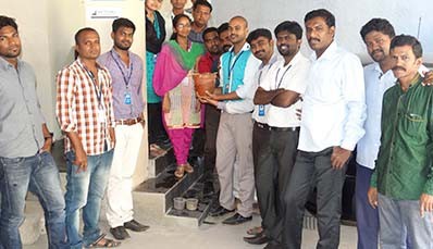 Guires team members holding a potted sapling at the sapling planting drive