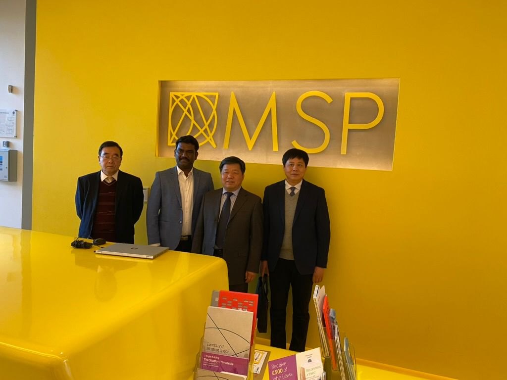 Guires and delegates in front of the MSP logo in Manchester